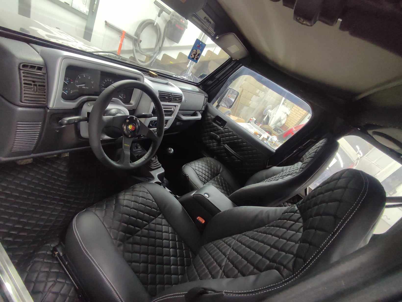 Interior view of a car with quilted leather seats and a modern dashboard.